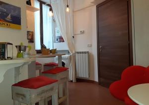 ナポリにあるChiaia Street Holidayの赤い椅子とドア付きのカウンター付きのキッチン