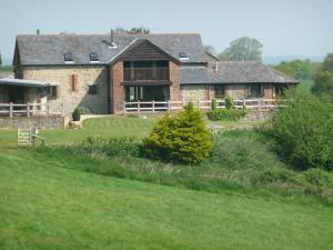 a large brick house with a green yard at Little Coombe, Bookham Court in Dorchester