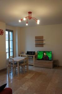 uma sala de estar com uma mesa e uma televisão num quarto em A casa dalla Fra 2 em Castelfranco Emilia