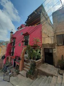 un edificio rojo con una escalera delante en Hostal Casa de Dante en Guanajuato