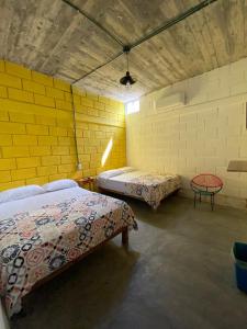 a room with two beds and a table in it at Mesón Carranza in Tamasopo +6 photos