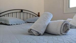 a white towel is laying on a bed at Sunset View Apartment in Néa Palátia