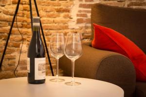 タラゴナにあるPlaça Forum - Mareのワイングラス2杯付きのテーブルに置かれたワイン1本