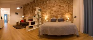 タラゴナにあるPlaça Forum - Mareのレンガの壁、大きなベッド付きのベッドルーム1室