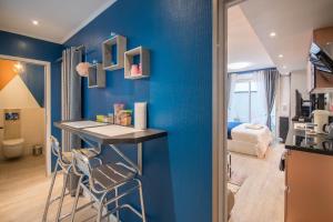 Cette chambre est dotée d'un mur bleu avec une table et des chaises. dans l'établissement MV Suite & Spa, à Reims
