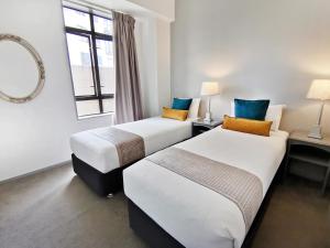 Кровать или кровати в номере Quest on Eden Serviced Apartments