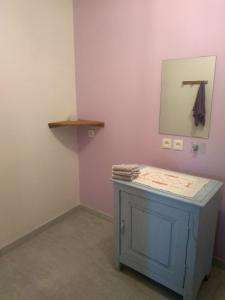 a bathroom with a blue cabinet and a mirror at La Dame de Messignac in Ternand