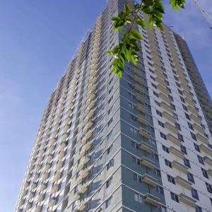 um edifício de apartamentos alto com um céu azul ao fundo em Cozy on the 28th! IT Park Cebu City em Cebu