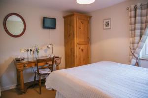 1 dormitorio con cama y escritorio con espejo en Yew Tree Farm en Congleton