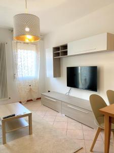 uma sala de estar com uma televisão de ecrã plano na parede em La casa di Paola em Solesino