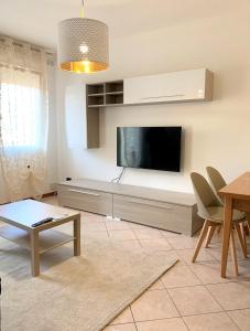 un soggiorno con una TV a schermo piatto su una parete di La casa di Paola a Solesino