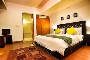 a bedroom with a large bed and a television at Sunset Residence and Condotel in Legian