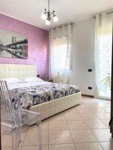 ein Schlafzimmer mit einem großen Bett und lila Wänden in der Unterkunft La casa di Paola in Solesino