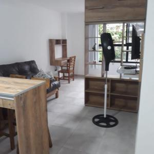 a living room with a black chair and a desk at Depto Temporario La Plata in La Plata