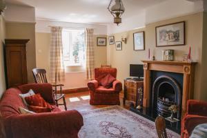 a living room with a fireplace and two chairs at Yew Tree Farm in Congleton