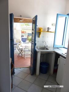 a kitchen with a door open to a patio at Appartamenti Villa Lina in Nisporto +39 photos