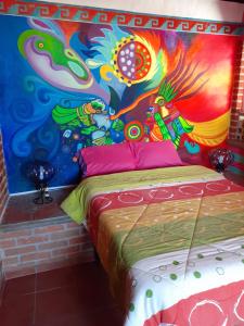 1 dormitorio con una pintura en la pared en Hostal Casa de Dante, en Guanajuato