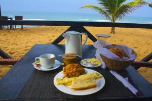 a table with a plate of food on the beach at Hôtel Résidence Madiba in Lomé