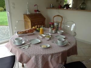 une table avec une nappe rose et de la nourriture dans l'établissement St Germain, à Saint-Germain-du-Corbéis