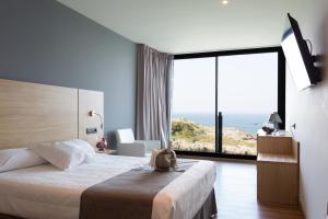 a hotel room with a bed and a large window at Hotel Astuy in Isla