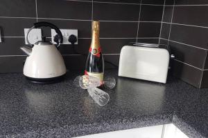 a bottle of champagne sitting on a counter next to a toaster at Rutland View in Oakham