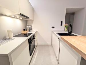 a kitchen with white cabinets and a counter top at Comfy Apartments - Old Town Center in Gdańsk
