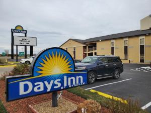 a sign for days inn with a car parked in a parking lot at Days Inn by Wyndham Lawton in Lawton