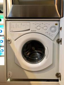 eine Waschmaschine mit einer Mikrowelle darüber in der Unterkunft Luxury Sea View BULLDOG Place in Warna