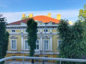 a large yellow building with an orange roof at Luxury Sea View BULLDOG Place in Varna City