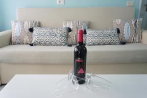 una bottiglia di vino seduta su un tavolo di fronte a un divano di Bright flat in Salinetas Beach a Telde