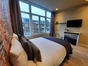 a bedroom with a large bed and a large window at RoomWest in Amsterdam