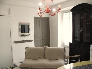 a living room with a couch and a chandelier at Maison Julien 3 in Menton