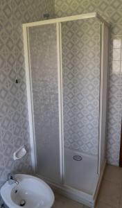 een badkamer met een douche en een witte wastafel bij Le Dimore del Sole LT in Cagliari