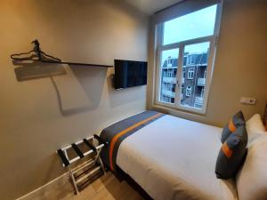 um quarto com uma cama e uma janela em RoomWest em Amsterdã