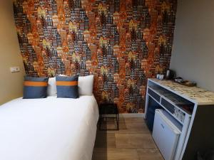 a bedroom with a bed and a wall covered in photos at RoomWest in Amsterdam