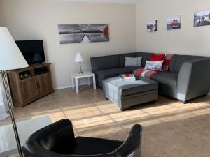 ein Wohnzimmer mit einem Sofa und einem Stuhl in der Unterkunft Condo Mont-Edouard in LʼAnse-Saint-Jean