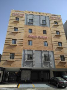 a building with a sign on the side of it at Al Rawda Jewel Apartment Hotel in Jeddah