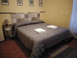 a bedroom with a bed with two towels on it at Casa Vacanze Le Rose in Ariccia