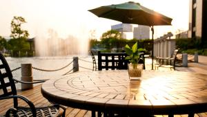 a wooden table with a potted plant and an umbrella at Crowne Plaza Deqing Moganshan, an IHG Hotel in Deqing