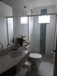 uma casa de banho com um lavatório, um WC e um chuveiro em Residencial helena cobertura em Bombinhas