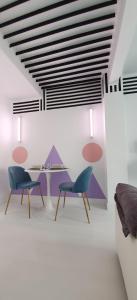 - un salon avec deux chaises et une table dans l'établissement Memphis design apartment, à Séville