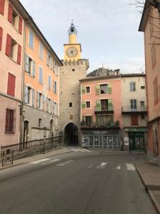 an empty street with a clock tower on a building at Studio Centre ville Castellane in Castellane