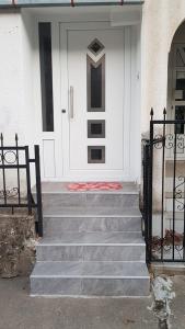 a white front door with stairs in front of a house at Apartment Centar in Kočani