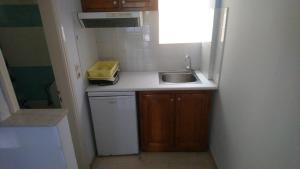 a small kitchen with a sink and a window at Tilegrafos Studios in Lefkada