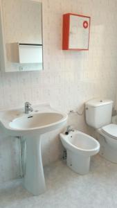 a bathroom with a sink and a toilet and a mirror at Casa la Pontiga in Las Rozas