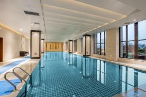 a large swimming pool with glass floors and windows at Crowne Plaza Hefei Rongqiao, an IHG Hotel in Hefei