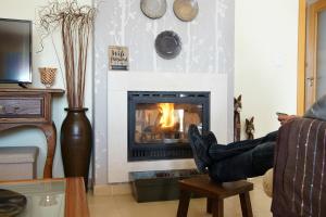 a person sitting on a chair in front of a fireplace at Monte das Pedras in Abrantes