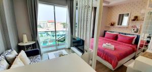 a small room with a red bed and a balcony at Sweet Seaview flr6 with toproop pool flr7 at The BluX Bangsaen in Ban Bang Saen (1) +29 photos