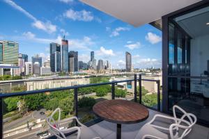 a balcony with a table and chairs and a city skyline at Hope Street Apartments by CLLIX in Brisbane