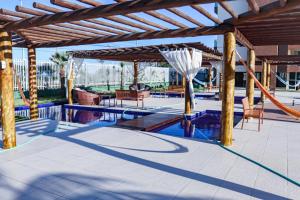 un patio con piscina y pérgola de madera en VG FUN - Apto 3 Quartos na Praia do Futuro - Vista Total pro Mar!, en Fortaleza